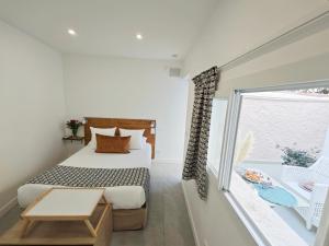 a bedroom with a bed and a large window at HOTEL DES CALANQUES in Cassis