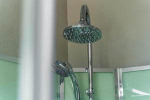 y baño con ducha y 2 cabezales de ducha. en Greenlake Guesthouse, en Maseru