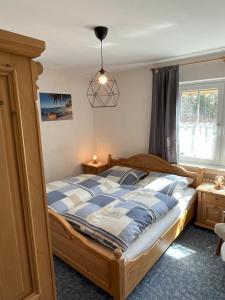 a bedroom with a bed with a blue and white comforter at Gästehaus Walter in Fichtelberg