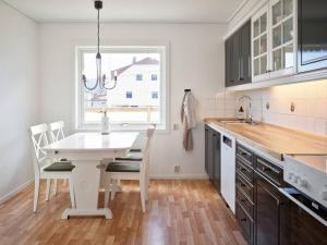 uma cozinha com uma mesa e cadeiras brancas e uma janela em Fjord Panorama em Stranda