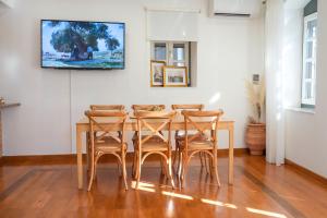a dining room with a table and four chairs at Naias Aegina, Sea-front apartment 95 sqm in Aegina Town