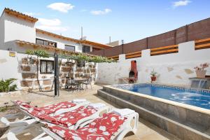 a villa with a swimming pool and two lounge chairs at Finca Keyfer in Vilaflor