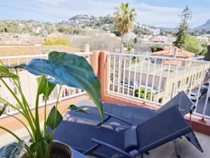 ein Balkon mit einer blauen Bank und einer Pflanze in der Unterkunft HOTEL DES CALANQUES Port de Cassis in Cassis + 84 Fotos