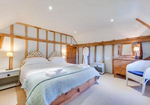 a bedroom with a large bed and a dresser at Iden Green Farm Stables in Benenden