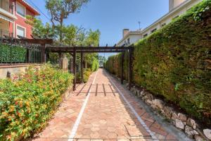 um caminho de tijolos com um portão num jardim em L34 Hermès Suite terrace parking AC 2mins SEA em Saint-Jean-Cap-Ferrat