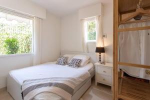een witte slaapkamer met een bed en een raam bij L34 Hermès Suite terrace parking AC 2mins SEA in Saint-Jean-Cap-Ferrat