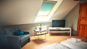 a living room with a couch and a tv at Apartamenty "Hubertówka" in Ochla