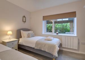 1 dormitorio con 2 camas y ventana en Little Orchard en Sedlescombe