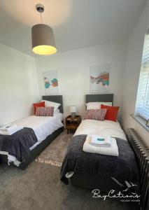 a bedroom with two beds and a couch at Stylish Brixham home, sleeps 7, parking & garden in Brixham
