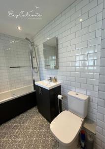 a bathroom with a white toilet and a sink at Stylish Brixham home, sleeps 7, parking & garden in Brixham