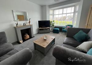 a living room with two couches and a fireplace at Stylish Brixham home, sleeps 7, parking & garden in Brixham
