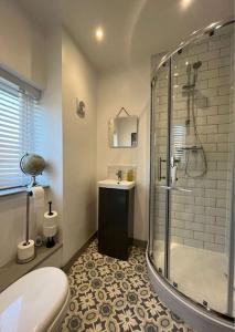 a bathroom with a shower and a toilet and a sink at Stylish Brixham home, sleeps 7, parking & garden in Brixham