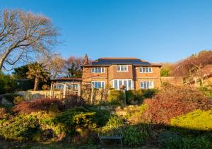 ein Backsteinhaus mit einem Sonnendach in einem Garten in der Unterkunft Melbury Abbas in Sandgate