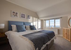Schlafzimmer mit einem großen Bett mit blauem Kopfteil in der Unterkunft Melbury Abbas in Sandgate