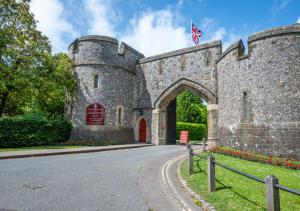 an old castle with a red door and a flag at Longmace in Arundel