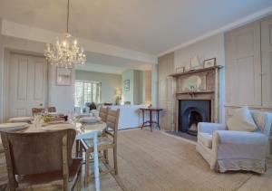 a dining room and living room with a table and a fireplace at Lower Coastguard Cottage in Hastings