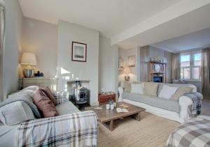 a living room with two couches and a table at Lower Coastguard Cottage in Hastings