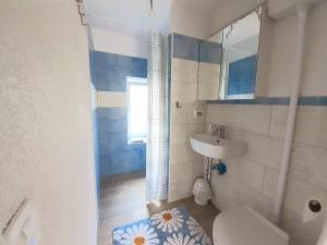 a bathroom with a sink and a toilet and a mirror at Apartment Vignole in Portorož