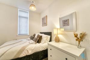 a bedroom with a bed with a dresser and a window at Guest Homes - The Bell Apartment in Stourbridge