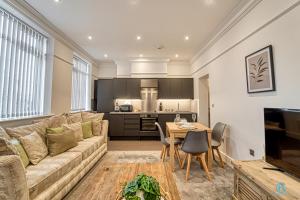 uma sala de estar com um sofá e uma mesa em Guest Homes - The Bell Apartment em Stourbridge