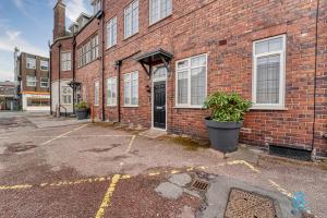 an empty parking lot in front of a brick building at Guest Homes - The Bell Apartment in Stourbridge