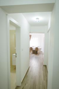 a white hallway with a dining room in the background at Sweet Home in Miercurea-Ciuc