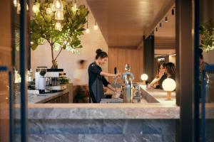 a woman standing at a bar in a restaurant at ASAI Bangkok Sathorn in Bangkok