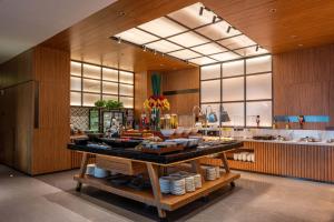 a kitchen with a buffet of food on a table at Urcove by HYATT Shanghai Wujiaochang in Shanghai