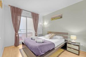 - une chambre avec un grand lit et une couverture violette dans l'établissement Prat d'Albis - Appt avec terrasse, à Toulouse