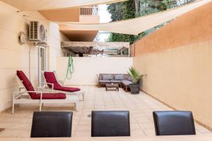 d'une terrasse avec des chaises rouges et un canapé. dans l'établissement Apartamento Ramon y Cajal, à Fuengirola