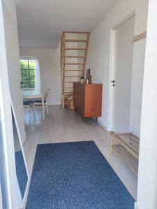 a living room with a table and a blue rug at Gästhus på Österlen med närhet till strand & golf in Ystad