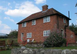 a large red brick house with a roof at Orchard Cottage in Sutton Valence