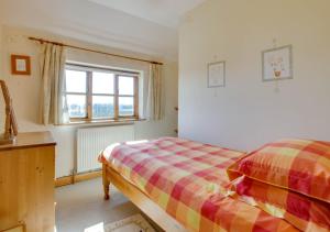 a bedroom with a bed and a window at Orchard Cottage in Sutton Valence