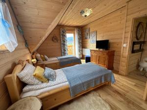 - une chambre avec 2 lits dans une cabane en rondins dans l'établissement Domek "Góraleczka " koło Karpacza - z widokiem na góry, à Sosnówka