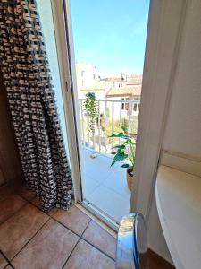 eine Glasschiebetür mit Blick auf einen Balkon in der Unterkunft HOTEL DES CALANQUES in Cassis