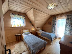 - une chambre avec 2 lits dans une cabane en rondins dans l'établissement Domek "Góraleczka " koło Karpacza - z widokiem na góry, à Sosnówka