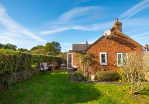 a brick house with a garden in front of it at One The Bungalows in Peasmarsh