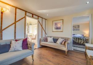 a living room with two couches and a bedroom at One The Bungalows in Peasmarsh