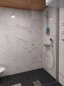 ein Bad mit einer Dusche und weißen Marmorwänden in der Unterkunft Keskusta uusi kalustettu kaksio. in Kuopio