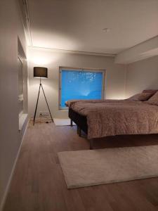 Schlafzimmer mit einem Bett und einem Fenster in der Unterkunft Keskusta uusi kalustettu kaksio. in Kuopio