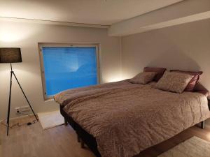 Un dormitorio con una cama grande y una ventana en Keskusta uusi kalustettu kaksio., en Kuopio