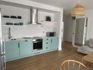 a kitchen with blue cabinets and a stove top oven at 2 Bedroom Apartment Central Town Location in Enniscorthy