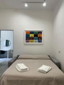 een slaapkamer met een bed met twee handdoeken erop bij Green Spera Apartment in Napels