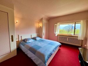 Un dormitorio con una cama grande y una ventana en Villa Champagne, en Champagne-en-Valromey