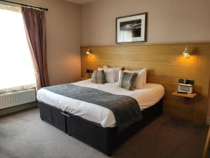 a bedroom with a large bed in a hotel room at The Black Hat in Ilkley