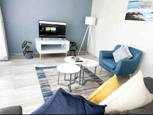 Una sala de estar con un sofá y un televisor. en Chic Modern House on Neasden - 2085, en Bulawayo