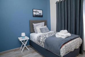 a blue bedroom with a bed with a teddy bear on it at Chic Modern House on Neasden - 2085 in Bulawayo