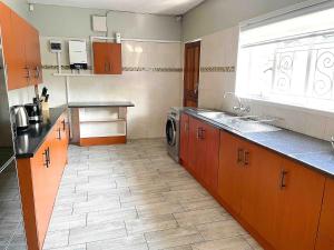 Il comprend une cuisine équipée d'un évier et d'un lave-linge. dans l'établissement Chic Modern House on Neasden - 2085, à Bulawayo