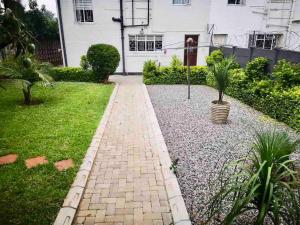 a brick walkway in front of a white house at Chic Modern House on Neasden - 2085 in Bulawayo