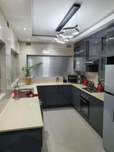 a large kitchen with black and white counters and appliances at Posh 3 bedroomed guesthouse in Hillside with pool - 2039 in Bulawayo